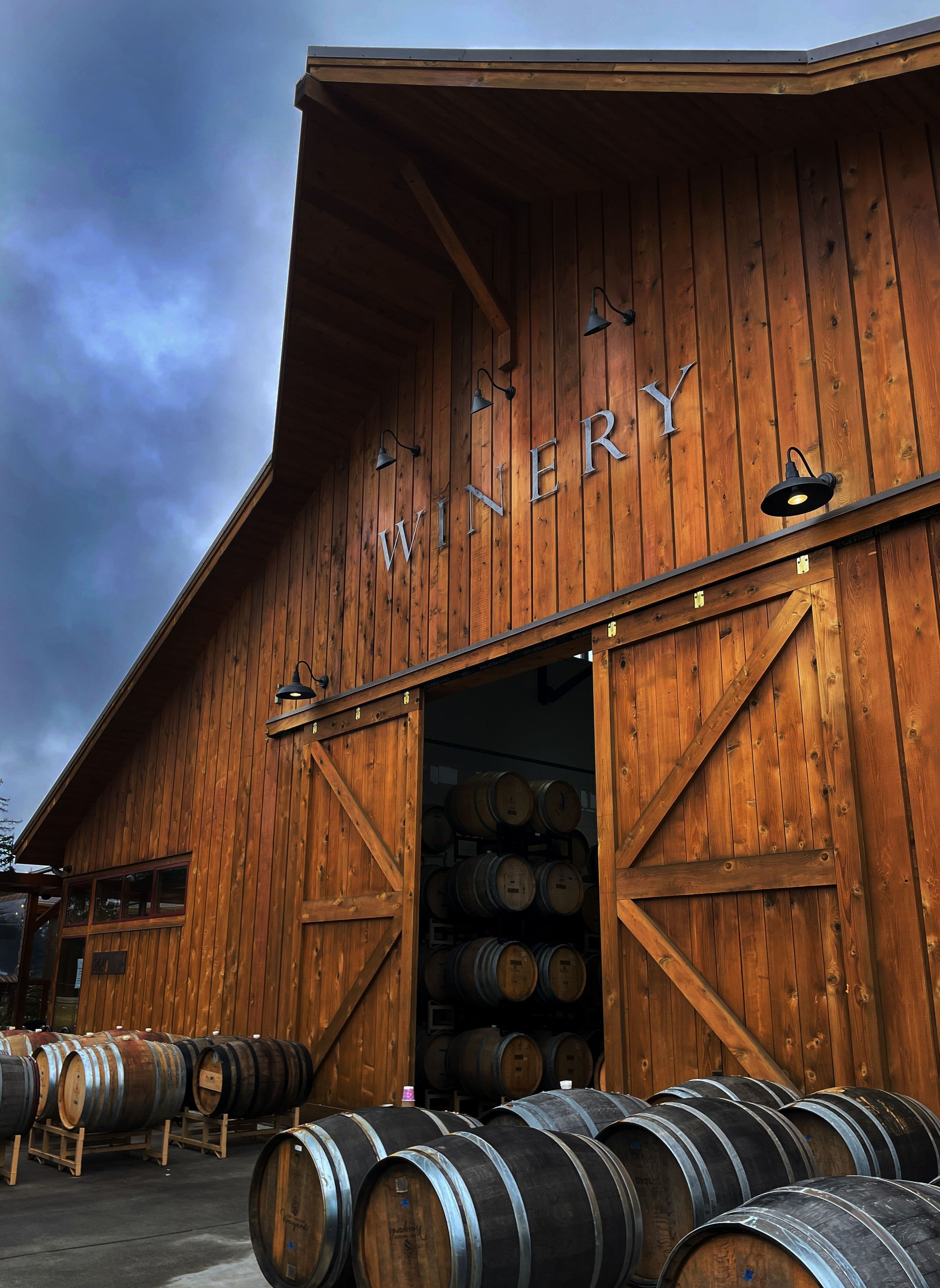 Fachada de una winery con barricas en el exterior